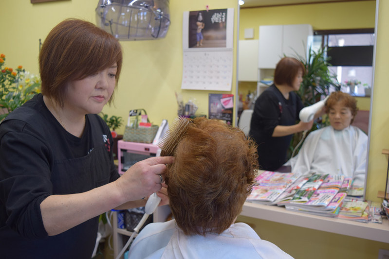 祖母、母と3代続く美容院を再建した本田英子さん(左)。人柄と腕の良さで客が絶えない=宮古市鍬ケ崎下町で