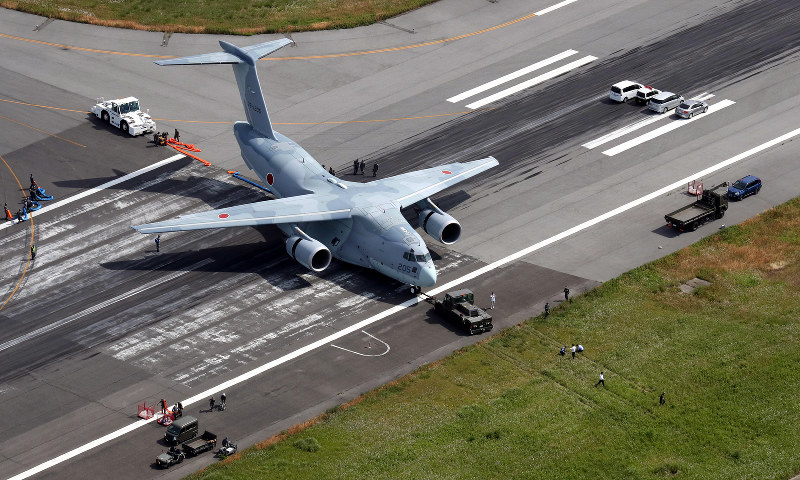 滑走路を外れて草地(手前)に突っ込み、移動された航空自衛隊のC2輸送機=鳥取県境港市の米子空港で2017年6月9日、本社ヘリから幾島健太郎撮影
