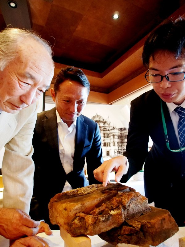 寄贈されたレンガ片を見る三好則夫さん(左)と嘉陽礼文会長ら=香川県観音寺市で2017年6月13日午後2時26分、寺岡俊撮影