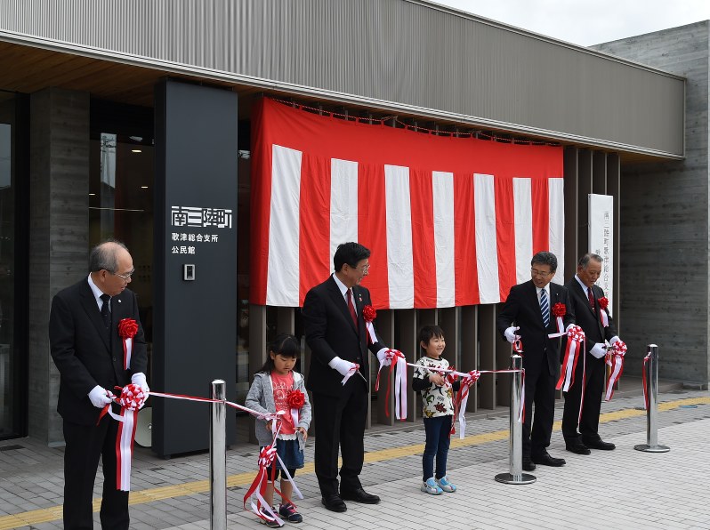 南三陸町歌津総合支所の完成を祝い、町関係者や保育園児らとテープカットをする佐藤仁町長(中央)