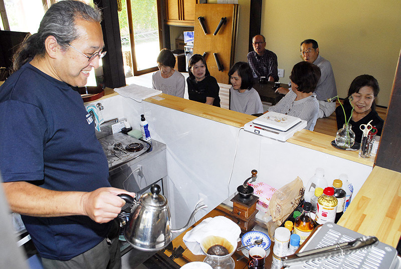 地域住民と談笑しながらコーヒーをいれる山野正憲さん(左端)=福井県美浜町で、近藤諭撮影
