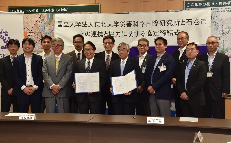 協定締結後、記念撮影する東北大災害科学国際研究所と石巻市役所の関係者=同市役所で