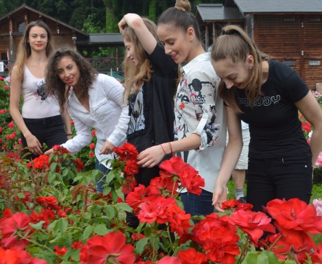 楽しそうにバラを眺めるブルガリアの新体操選手団＝村山市の東沢バラ公園で