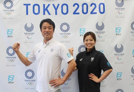 東京五輪（左）、パラリンピック（右）のエンブレム入りポロシャツを着る菊地豊市長（左）と職員＝伊豆市役所で