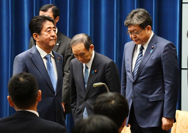 記者会見を終え会場を後にする安倍晋三首相（左）を見送る菅義偉官房長官（中央）と萩生田光一官房副長官（右）＝首相官邸で２０１７年６月１９日午後６時４０分、川田雅浩撮影