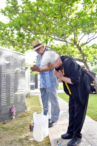戦没者の名前が刻まれた「平和の礎」の前で、手を合わせて冥福を祈る遺族＝沖縄県糸満市の平和祈念公園で２０１７年６月２３日午前６時５４分、森園道子撮影