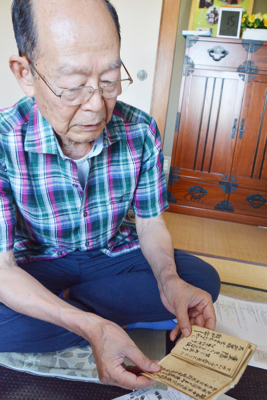 祖父朝義さんの手配を手にする伊地文夫さん=高松市牟礼町で、岩崎邦宏撮影