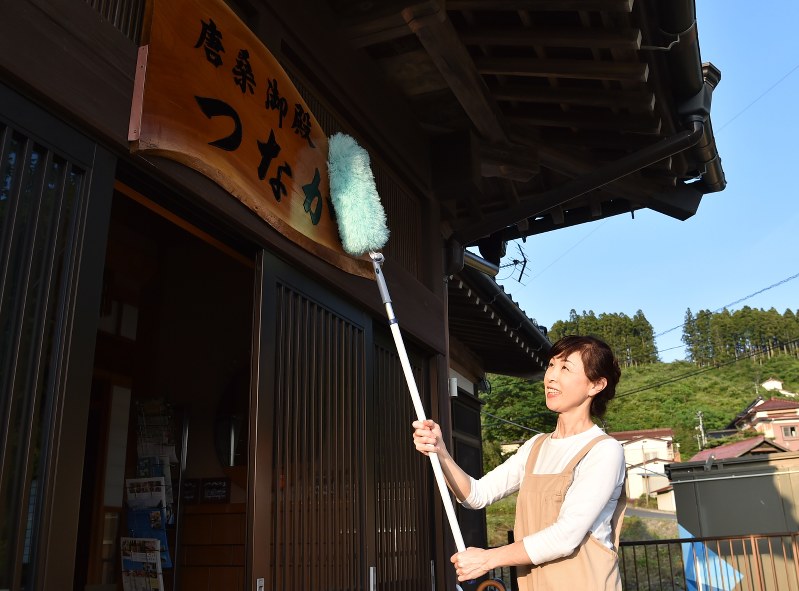 25日の営業再開に向け、民宿の看板を掃除する菅野一代さん=宮城県気仙沼市唐桑町で