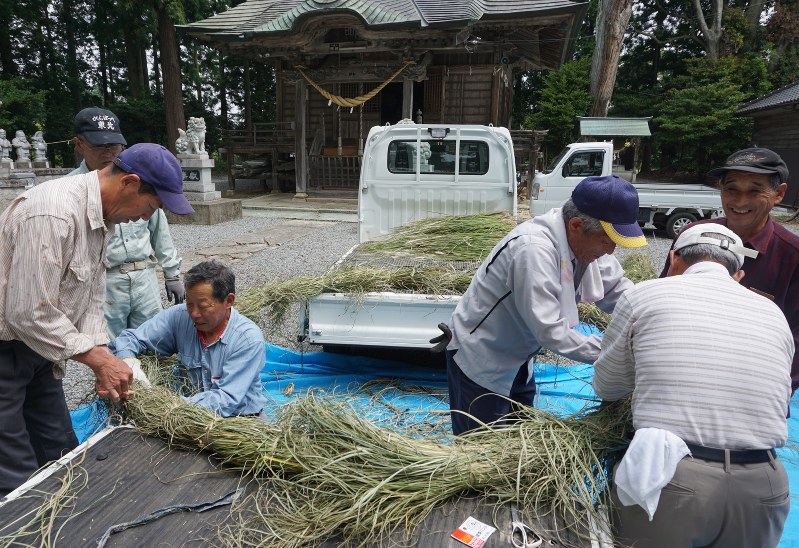 茅カヤを結い付けて茅の輪をつくる住民ら=南相馬市原町区高で