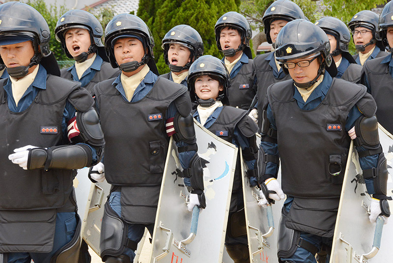 盾を持ち、隊列に加わって走り込みの訓練に臨む木原真希記者(中央)=和歌山市木ノ本で、最上和喜撮影