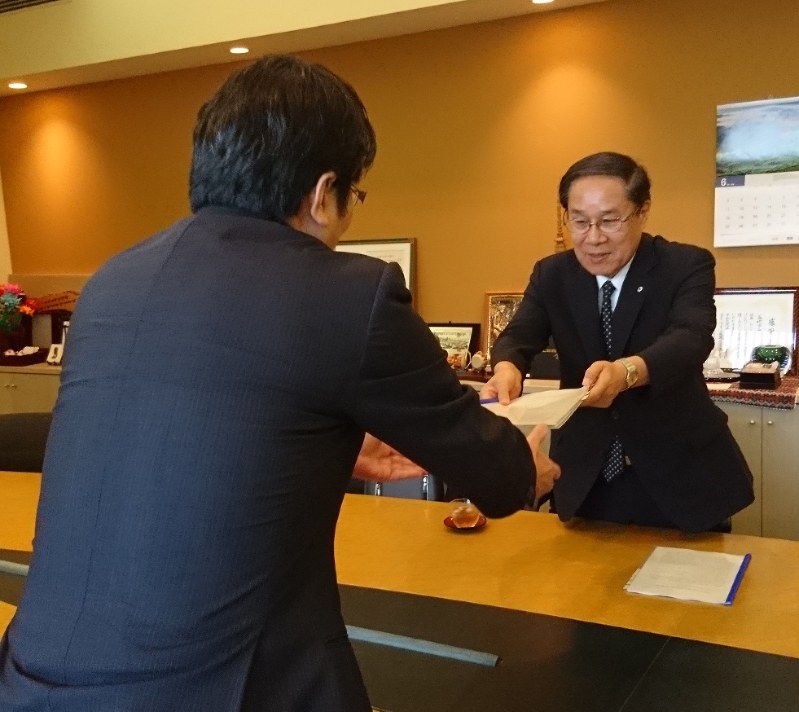 田上市長(左)に帰国報告書を手渡す朝長さん