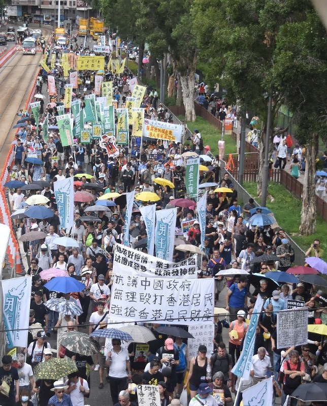 中国政府に抗議する横断幕などを掲げ、デモ行進する市民ら=香港・銅鑼湾地区で1日、福岡静哉撮影