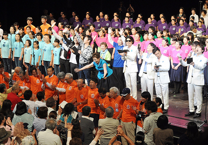 ステージ上と聴衆が一緒に「琵琶湖周航の歌」を大合唱したびわ湖音楽祭のフィナーレ。中央で両手を伸ばしているのが加藤登紀子さん=大津市のびわ湖ホールで、塚原和俊撮影