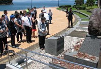 条約発効記念行事を前に水俣病犠牲者慰霊碑で黙とうする各国政府関係者ら＝熊本県水俣市で１日午前11時５２分