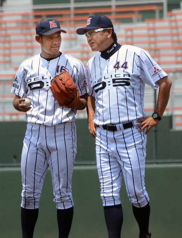 試合中、タイムを取りマウンドでアドバイスを送る加藤伸一投手コーチ(右)=鹿児島市の県立鴨池野球場で6月4日午、生野貴紀撮影