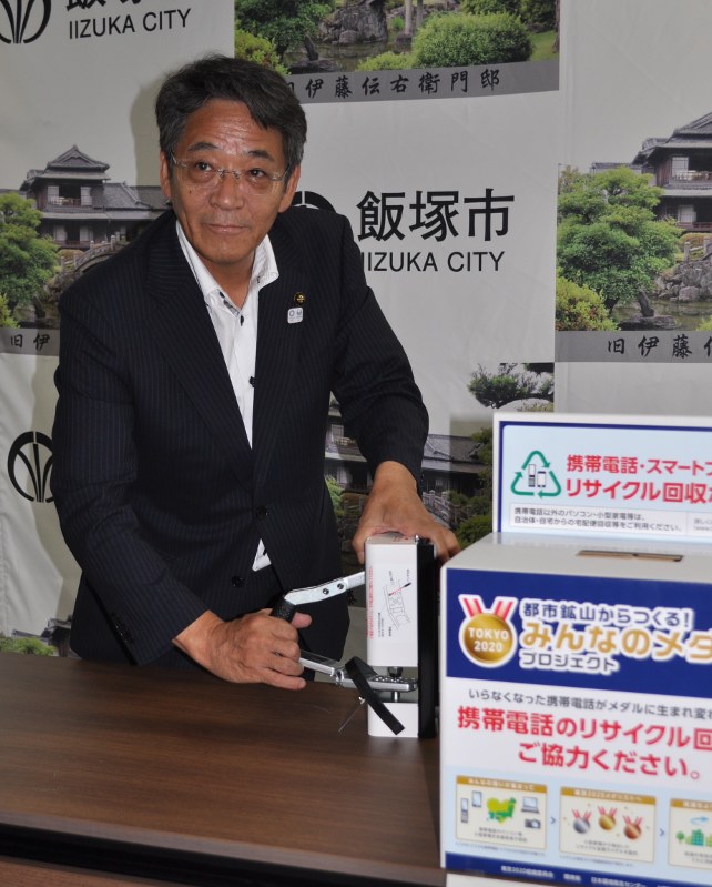 不要になった携帯電話機を破壊する「携帯パンチ」を操作する片峯誠市長