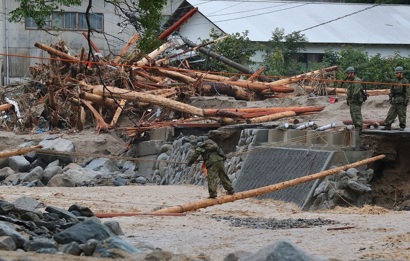 行方不明者の捜索活動のため川を渡る自衛隊員ら=福岡県朝倉市で7日午前7時55分、長谷川直亮撮影