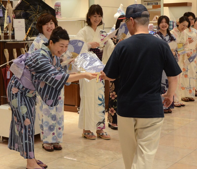 浴衣姿でうちわを配る従業員=仙台市青葉区の仙台三越で