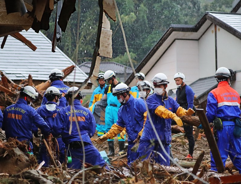 降り続く雨の中、安否不明者の捜索活動をする消防隊員ら=福岡県朝倉市杷木地区で2017年7月9日午前10時20分、長谷川直亮撮影