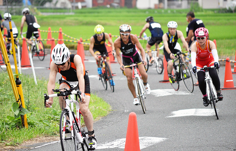 スイムに続いてバイクに挑むトライアスロン参加選手=滋賀県高島市宮野で、塚原和俊撮影