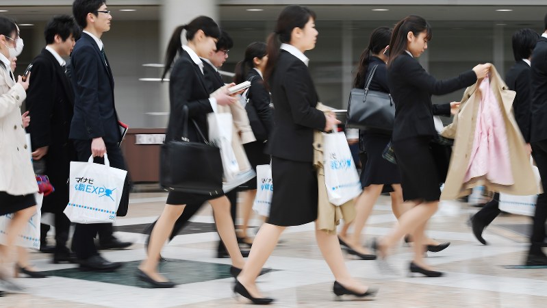 仕事と育児を両立できるか、就職を目指す女子学生は真剣に考えている。写真はリクルートスーツで合同企業説明会に向かう学生たち=2017年3月11日、宮間俊樹撮影