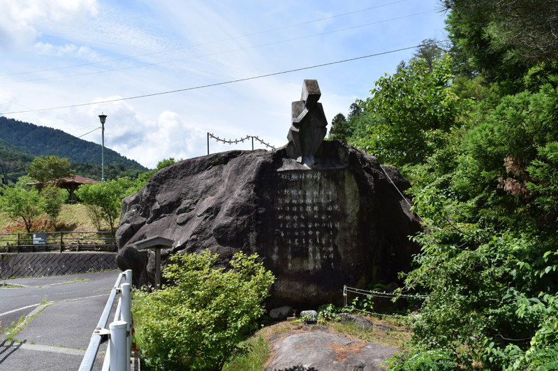 土石流に対する教えが表面に刻まれている「蛇ぬけの碑」。碑の上部には「悲しめる乙女の像」が安置されている