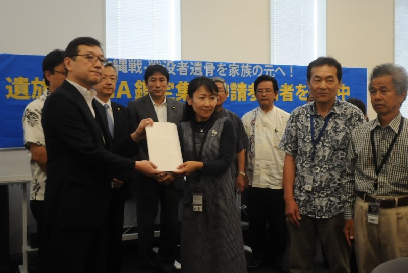 DNA鑑定の実施を求める要望書を厚生労働省の担当者(左)に手渡す戦没者の遺族や支援者=東京都千代田区の参院議員会館で2017年7月12日、熊谷豪撮影