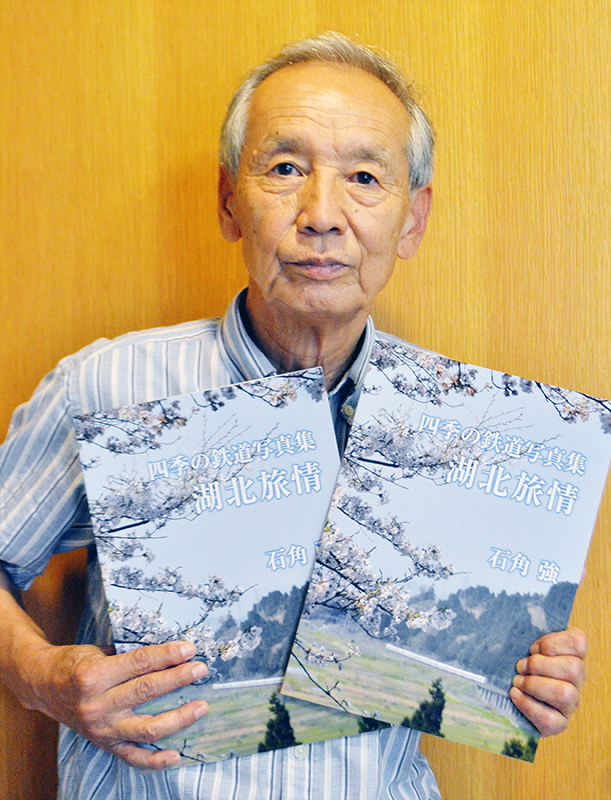 自主出版した鉄道風景写真集を手にする石角強さん=滋賀県高島市役所で、塚原和俊撮影