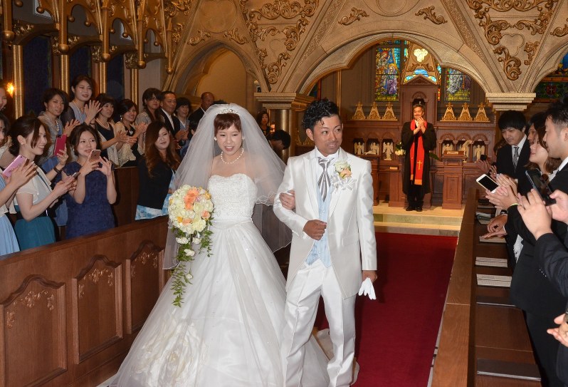 結婚式を挙げ、親族や友人らに祝福される堀さん夫妻