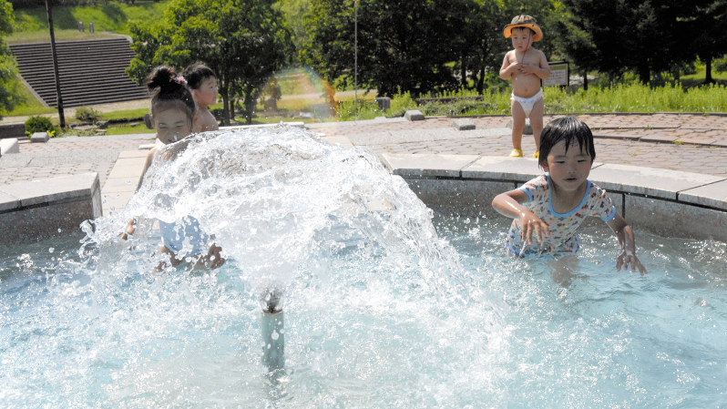 最高気温が37度となった北海道美幌町の噴水で涼む子どもたち=2017年7月15日