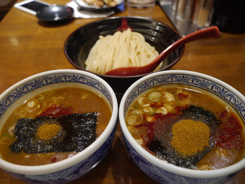 三田製麺所「灼熱つけ麺」の「1辛」(手前左)と「極限」(手前右)。粉末は激辛スパイス=東京都港区で2017年6月20日、中村かさね撮影