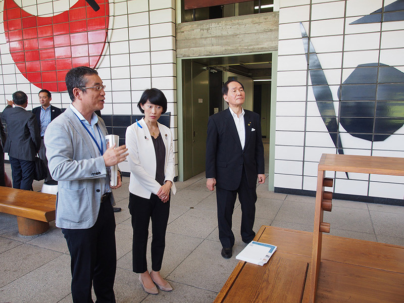 香川県の担当者(左)から陶板壁画や完成当初からある椅子などの説明を受ける丸川五輪担当相(右から2人目)=香川県庁東館で、植松晃一撮影