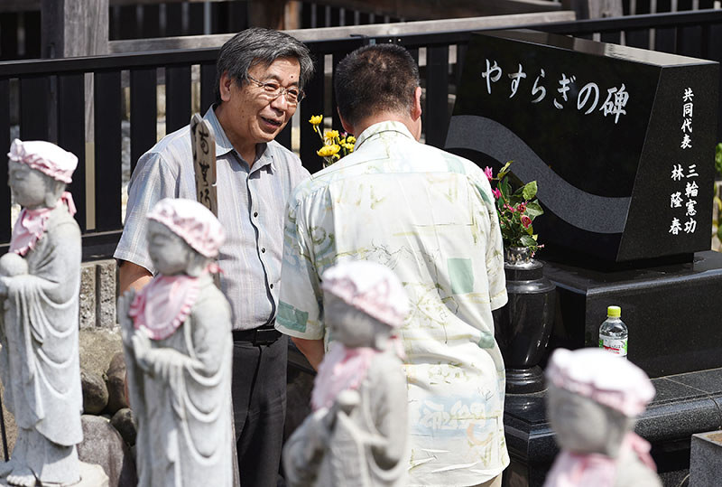 永代供養墓を建てたボランティア団体代表の三輪憲功さんと話す男性(手前)=愛知県一宮市で2017年7月8日、木葉健二撮影