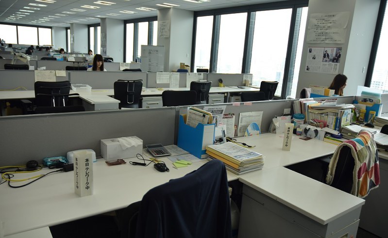 閑散としたオフィスの机には「本日テレワーク中」との目印が=東京都千代田区の明治安田生命保険本社で24日午前10時過ぎ