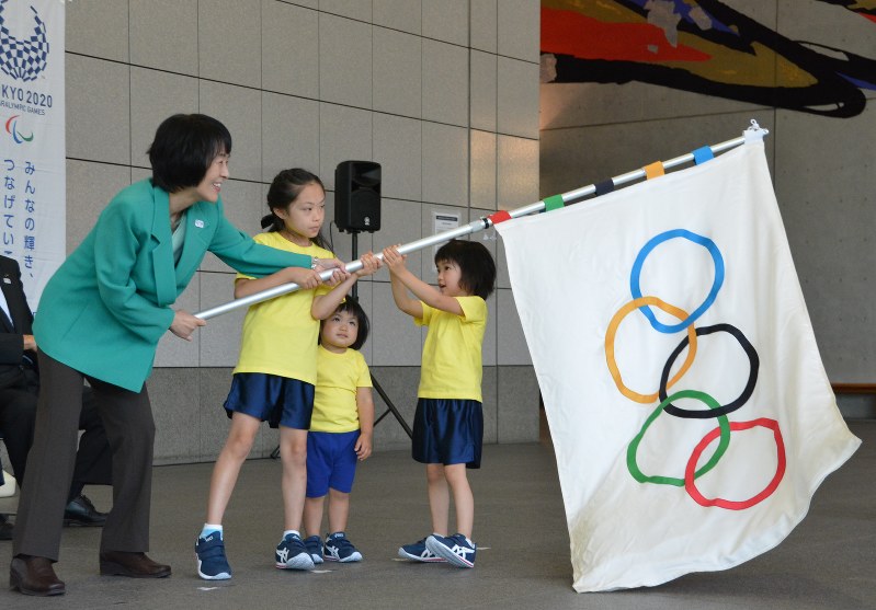 受け取った五輪旗を振る高橋はるみ知事=札幌市豊平区で