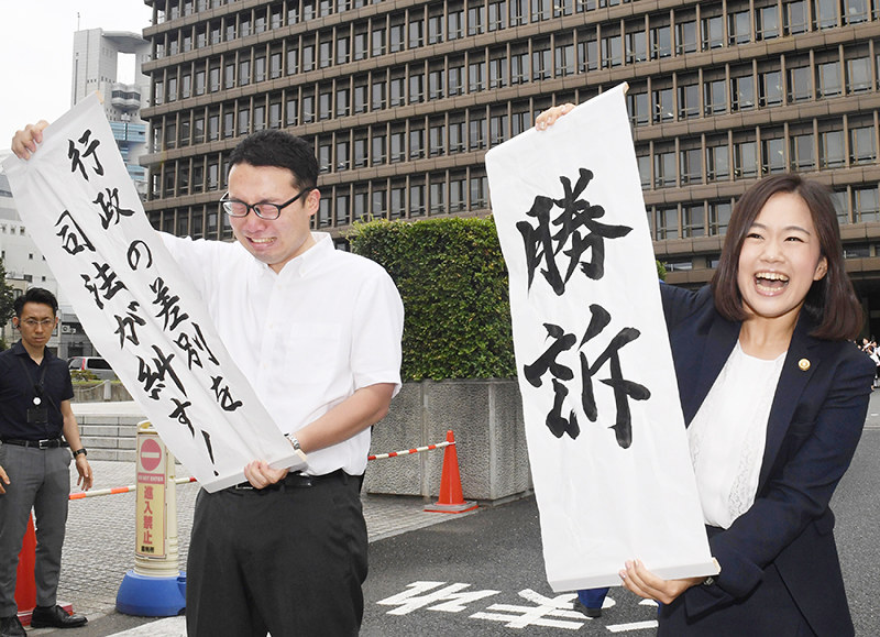 「勝訴」の垂れ幕を掲げ喜ぶ大阪朝鮮高級学校側の弁護士ら=大阪市北区で2017年7月28日午前11時7分、大西岳彦撮影