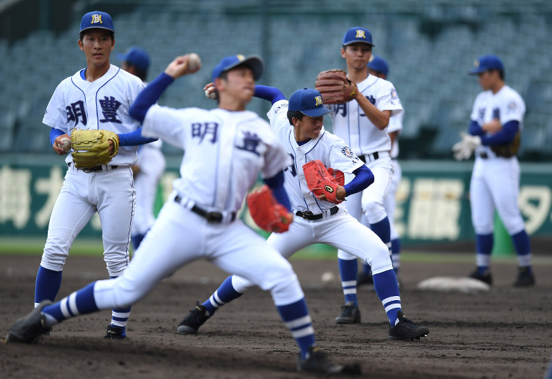 投球練習をする明豊の選手たち