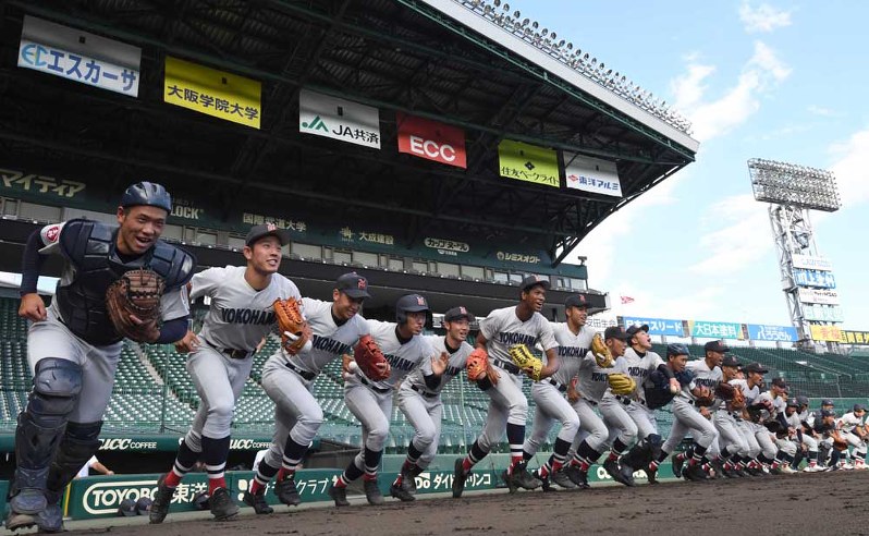 一斉にグラウンドへ駆け出す横浜の選手たち=阪神甲子園球場で、平川義之撮影