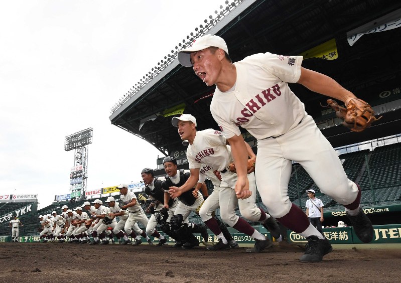 一斉にグラウンドへ駆け出す東筑の選手たち