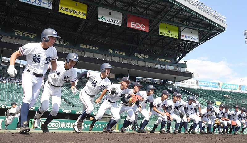 一斉にグラウンドへ駆け出す日本航空石川の選手たち=阪神甲子園球場で、平川義之撮影