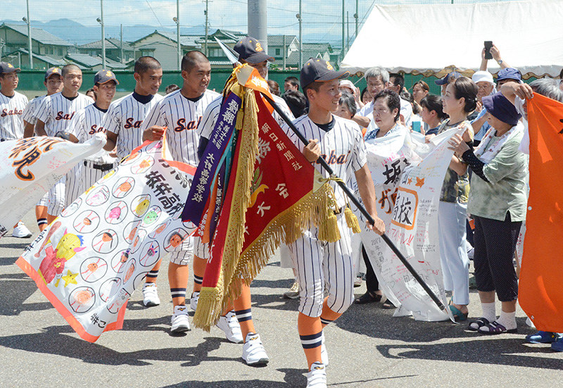 住民らに見送られながらバスに乗り込む選手たち=福井県坂井市の県立坂井高校で、大森治幸撮影