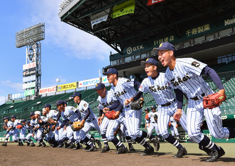 一斉にグラウンドへ駆け出す東海大菅生の選手たち=阪神甲子園球場で、猪飼健史撮影