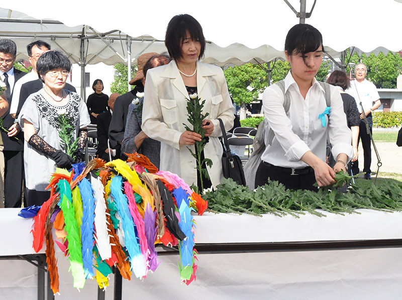 献花する参列者=広島県福山市霞町1の中央公園で、藤田祐子撮影