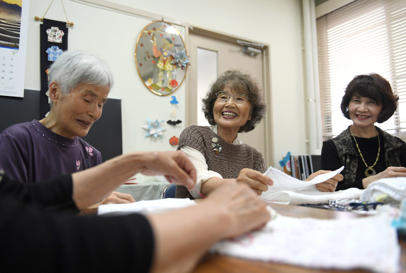 雑巾を手縫いする柳野恵子さん(中央)ら「手作りぞうきんの会」のメンバー=大阪狭山市で5月25日、久保玲撮影