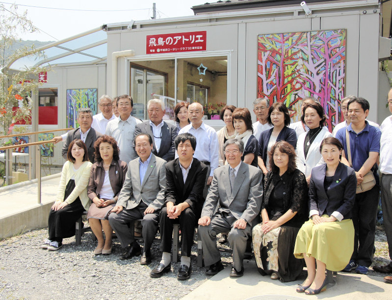 完成した絵画サロンの前で家族らと記念写真に納まる田崎飛鳥さん(前列中央)=岩手県陸前高田市横田町で
