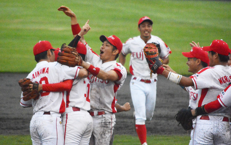 東北大会で初優勝を決め、マウンドに集まって勝利を喜ぶ富士通アイソテッククの選手たち=鶴岡市の鶴岡ドリームスタジアムで