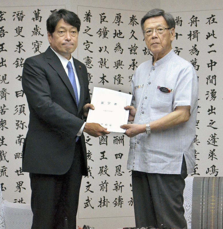 沖縄県の翁長雄志知事(右)から小野寺五典防衛相に要望書が渡された=那覇市の沖縄県庁で14日、佐藤敬一撮影