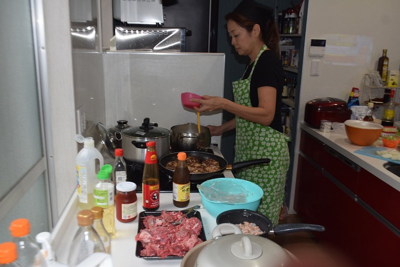 豚肉を煮て、ハンバーグを焼きながらスープにとき卵を投入する曽原絵理子さん