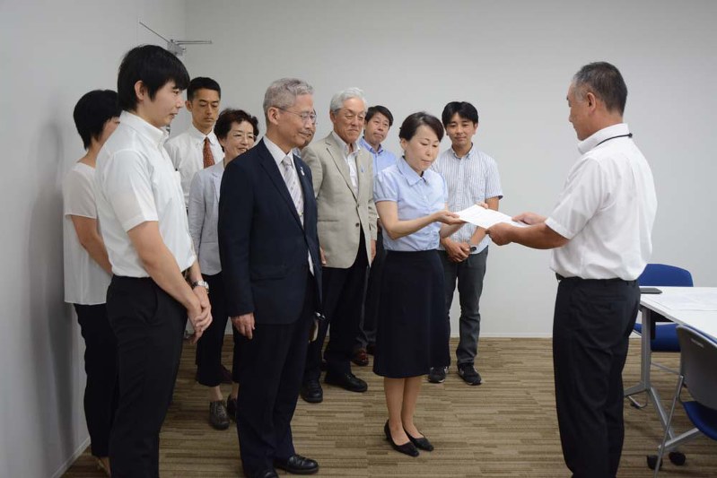 習志野市健康支援課長(右)に要望書を提出する「スモークフリーキャラバン in 千葉」のメンバー=習志野市鷺沼の習志野市役所で