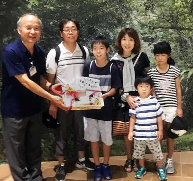 大昆虫博の来場者が10万人を突破し、上田館長(左)から記念品を受け取る富田晴彦さん(左から3人目)と家族ら=北九州市八幡東区の北九州市立いのちのたび博物館で2017年8月24日、橋本勝利撮影